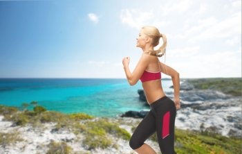 fitness and diet concept - beautiful sporty woman running or jumping