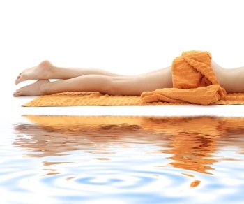 long legs of relaxed lady with orange towel on white sand