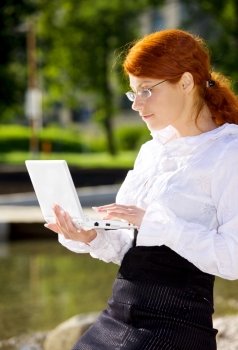 businesswoman with laptop computer in the park