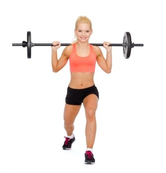 fitness, sport and exercise concept - smiling sporty woman with barbell doing split squat or lunge
