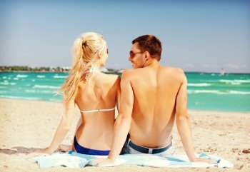 picture of happy couple sitting on the beach