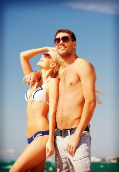 picture of happy couple in sunglasses on the beach, focus on man