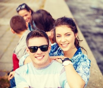 summer holidays, relationships and teenage concept - smiling teenagers having fun outside