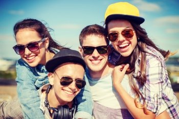 summer holidays and teenage concept - group of smiling teenagers hanging outside