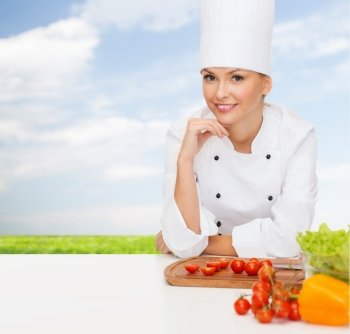cooking and food concept - smiling female chef with vegetables