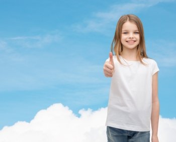 t-shirt design and happy people concept - smiling little girl in blank white t-shirt showing thumbs up