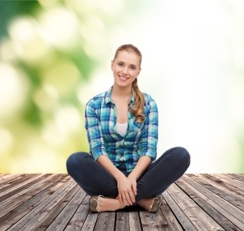 happiness and people concept - smiling young woman in casual clothes sitting on floor