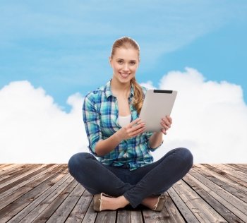 happiness, technology, internet and people concept - smiling young woman in casual clothes sitting on floor with tablet pc computer