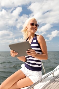vacation, holidays travel, sea and technology concept - smiling woman sitting on yacht with tablet pc