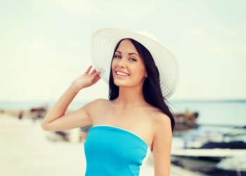 summer holidays and vacation concept - girl in hat standing on the beach