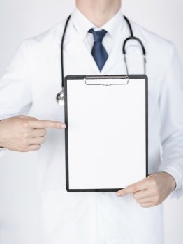 close up of doctor pointing at blank white paper