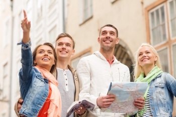 travel, vacation and friendship concept - group of smiling friends with city guide and map exploring city