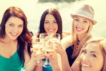 summer holidays, vacation and celebration concept - smiling girls with champagne glasses