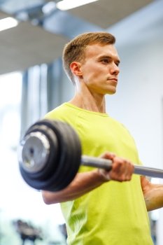 sport, fitness, lifestyle and people concept - man doing exercise with barbell in gym
