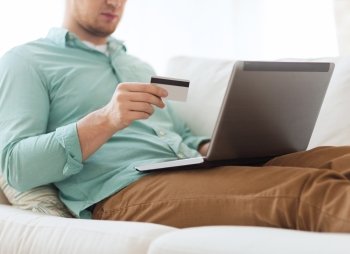technology, shopping, banking, home and lifestyle concept - close up of man with laptop computer and credit card at home