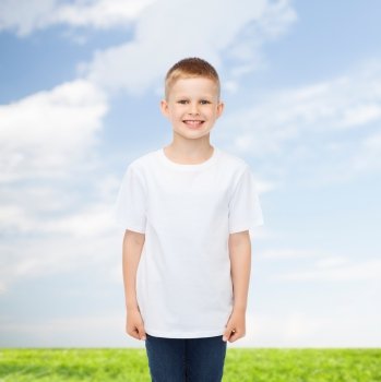 advertising, people, summer and childhood concept - smiling little boy in white blank t-shirt over natural background