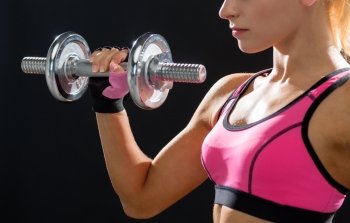 fitness, healthcare and dieting concept - close up of young sporty woman with heavy steel dumbbell