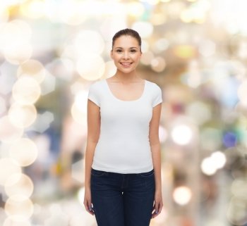 advertising, holidays and people concept - smiling young woman in blank white t-shirt over sparkling background