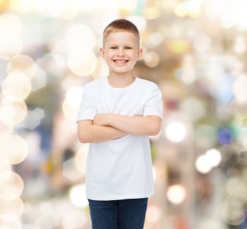 advertising, holidays, party, people and childhood concept - smiling little boy in white blank t-shirt over sparkling background