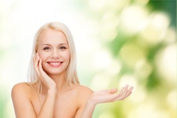 health, cosmetics, advertising and beauty concept - smiling woman holding imaginary lotion jar and applying it