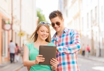 travel, vacation, technology and friendship concept - smiling couple with tablet pc computer in city