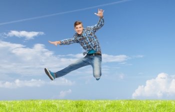 happiness, freedom, vacation, summer and people concept - smiling young man jumping in air over natural background