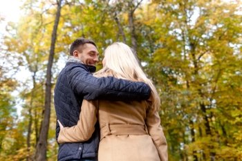 love, relationship, family and people concept - smiling couple hugging in autumn park