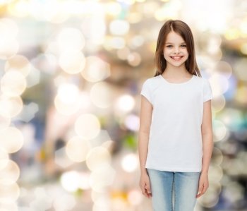 advertising, childhood, holidays and people - smiling little girl in white blank t-shirt over sparkling background