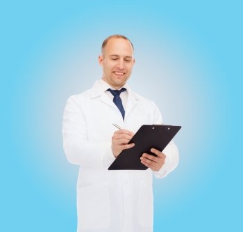 medicine, profession and healthcare concept - smiling male doctor with clipboard writing prescription over blue background