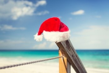 beach, summer, vacations, christmas and sea concept - close up of santa helper hat on beach