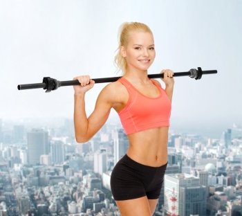fitness, sport and exercise concept - smiling sporty woman exercising with barbell