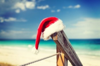 beach, summer, vacations, christmas and sea concept - close up of santa helper hat on beach