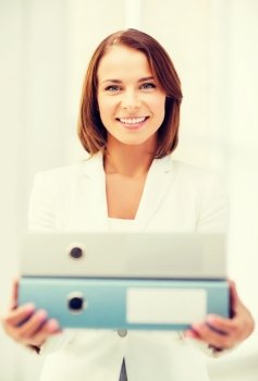office and business concept - smiling attractive businesswoman with folders in office