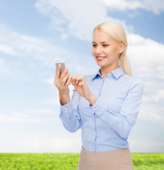 business, technology, internet and education concept - smiling young businesswoman with smartphone