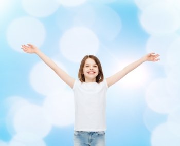 advertising, gesture, childhood and people - smiling little girl in white blank t-shirt with stretched out arms over blue background