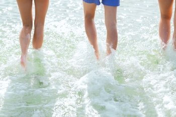 sea, summer vacation, holidays and people concept - close up of human legs walking on summer beach