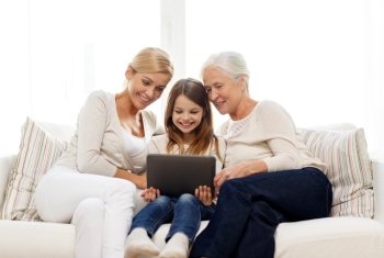 family, generation, technology and people concept - smiling mother, daughter and grandmother with tablet pc computer sitting on couch at home