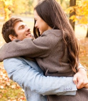 love, relationship, family and people concept - smiling couple hugging in autumn park