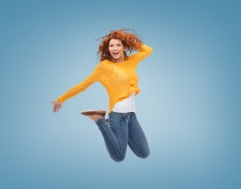 happiness, freedom, movement and people concept - smiling young woman jumping in air over blue background