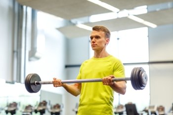 sport, fitness, lifestyle and people concept - man doing exercise with barbell in gym