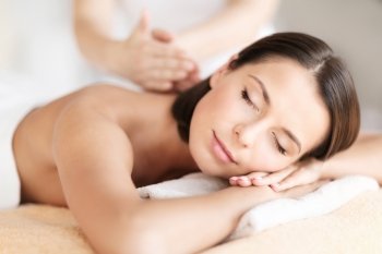 health, beauty, resort and relaxation concept - beautiful woman with closed eyes in spa salon getting massage
