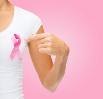 healthcare, people, charity and medicine concept - close up of woman in t-shirt with breast cancer awareness ribbon over pink background