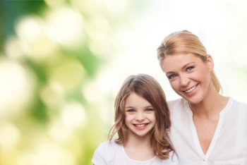 family, childhood, happiness, ecology and people - smiling mother and little girl over green background
