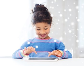 education, winter, technology and people concept - smiling little girl with tablet pc at home