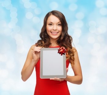 christmas, holidays, technology and people concept - smiling woman in red dress with tablet pc computer over blue lights background