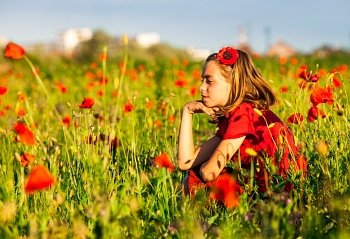 Girl sit in the poppies field and enjoy the nature