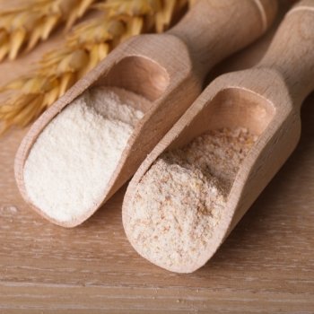 Meal and flour in the wooden spoon closeup