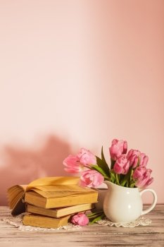 Poem still life with books and pink tulips with copy space. Teacher’s day.