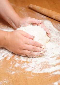 Flour in capacity with dough on the wooden table