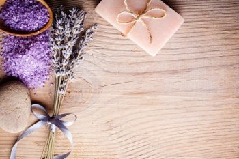 Lavender treatment soap, sea salt and stone on wooden table with copy space